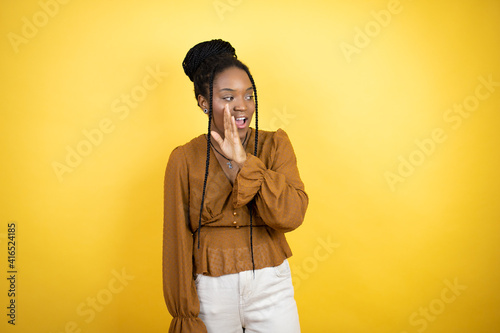 African american woman wearing casual clothes hand on mouth telling secret rumor, whispering malicious talk conversation © Irene