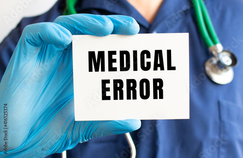 Doctor holding a card with text MEDICAL ERROR. Medical concept.