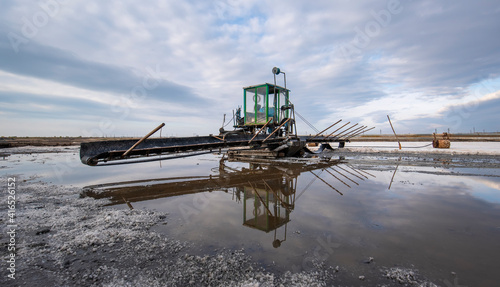 Machine gathering salt on Pomorie salt lake in Bulgaria. Harvesting sea salt 