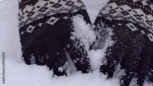 Close up of hands playing with powdery fluffy snow. Wearing woven gloves with nordic pattern. High quality audio recording of crunching sound of fresh snow. ASMR style video and audio.