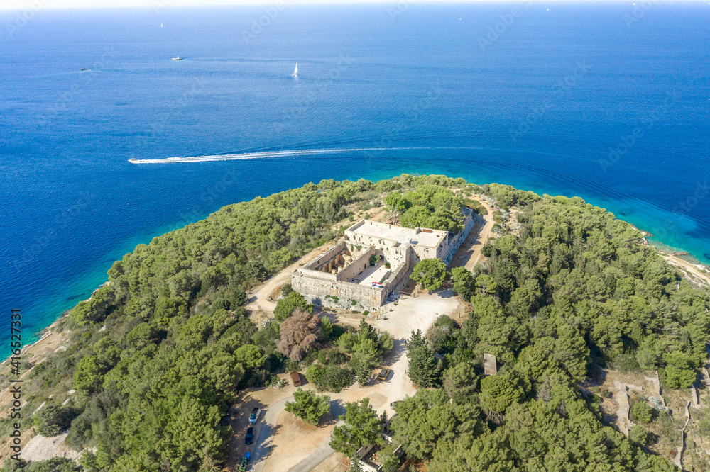 Aerial drone shot of stone Fort George Croatia on top of hill in Adriatic sea on Vis Island in summer