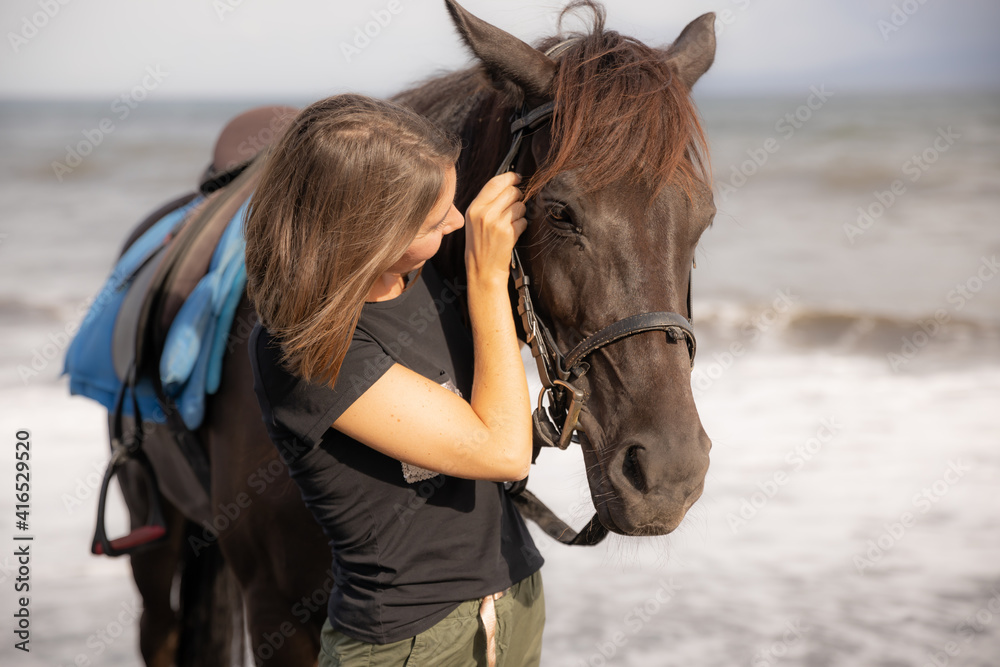 Obraz premium Portrait of young woman and brown horse. Young Caucasian woman hugging horse. Romantic concept. Love to animals. Nature concept. Bali