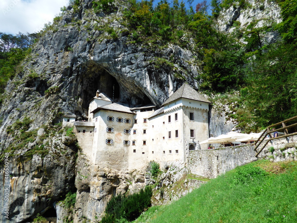 Vista general del Castillo de Predjama (Eslovenia) incrustado en una roca a media altura de una montaña y sirviendo de entrada a una cueva