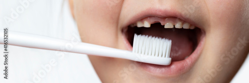 Baby's mouth with a milk tooth hole and a toothbrush. Teeth brushing, teeth counting