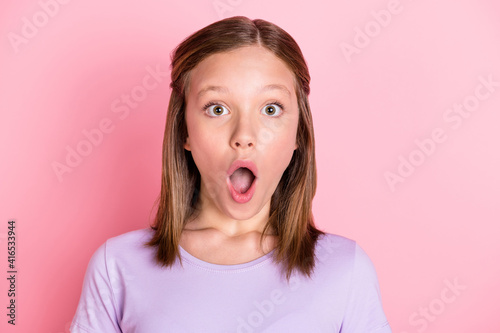 Photo of shocked amazed small girl information unexpected news isolated on pastel pink color background