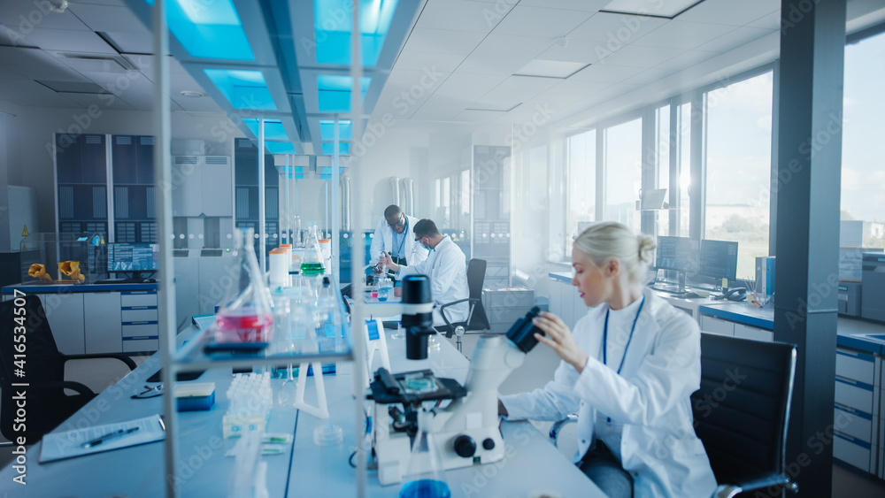 Modern Medical Research Laboratory: Team of Scientists Working with Pipette, Analysing Microbiological Sample, Talking. Advanced Scientific Lab for Drugs, Microbiology Development. High-Tech Equipment Modern Medical Research Laboratory: Team of Scientists Working with Pipette, Analysing Microbiological Sample, Talking. Advanced Scientific Lab for Drugs, Microbiology Development. High-Tech Equipment