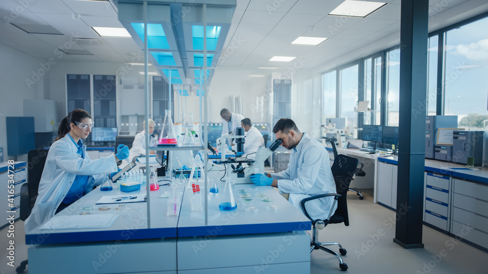 Obraz premium Modern Medical Research Laboratory: Diverse Team of Scientists Working Using Microscope, Analysing Microbiology Samples. Scientific Lab for Medicine, Biotechnology Development. Advanced Equipment