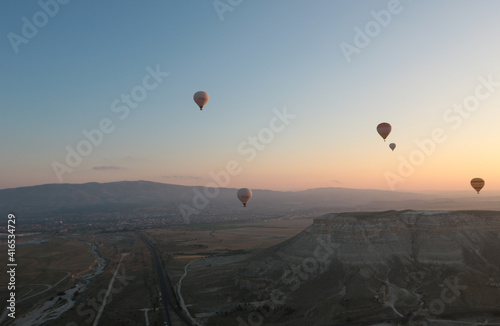 aerial view of a group of hot air balloons flying at down in cappadocia