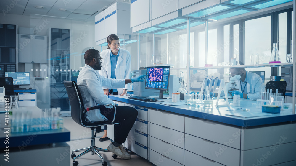Obraz premium Modern Medical Research Laboratory: Two Scientists Use Computer with Screen Showing DNA Gene Analysis, Specialists Discuss Innovative Technology. Advanced Scientific Lab for Medicine, Biotechnology