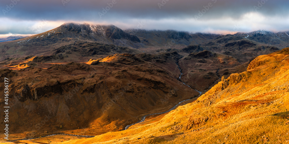 Panoramic view of Englands highest mountain; Scafell Pike. Taken in the golden hour, overlooking the Eskdale Needle, Lake District, UK.
