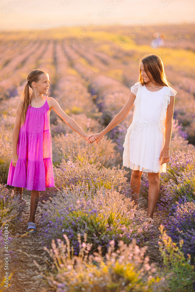 Girls in lavender flowers field at sunset in white dress Girls in lavender flowers field at sunset in white dress