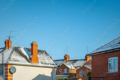 Houses roofs covered with winter snow in england uk