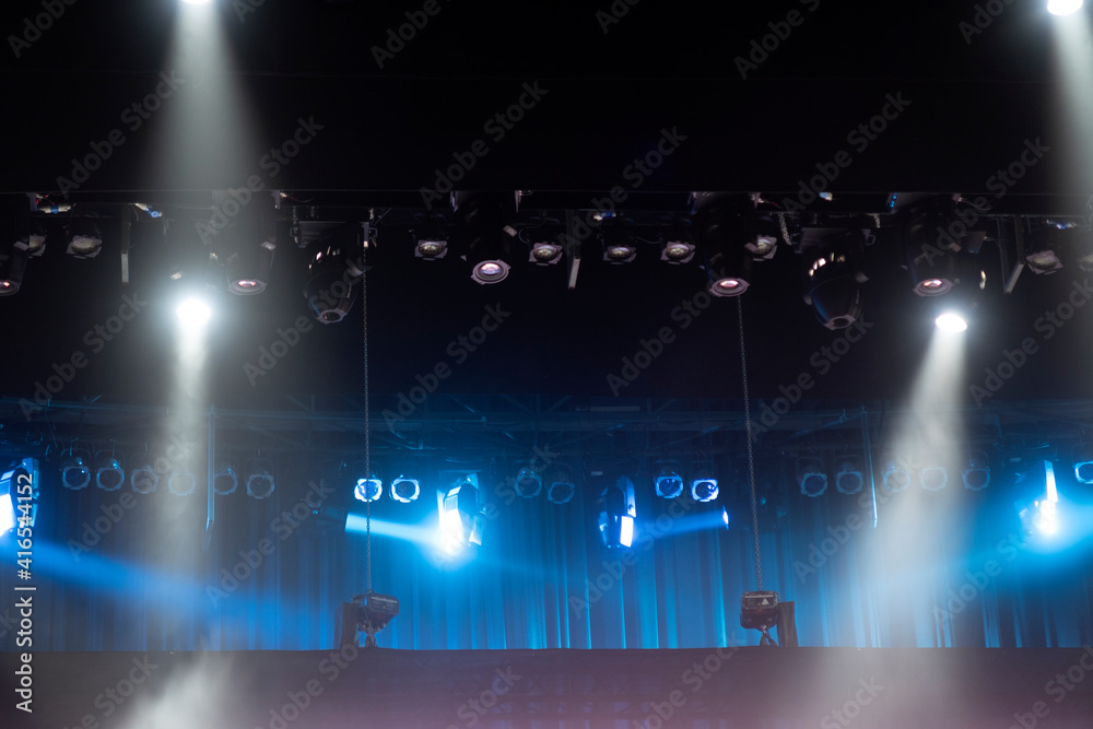 Stage lights on concert. Lighting equipment with multicolored beams.