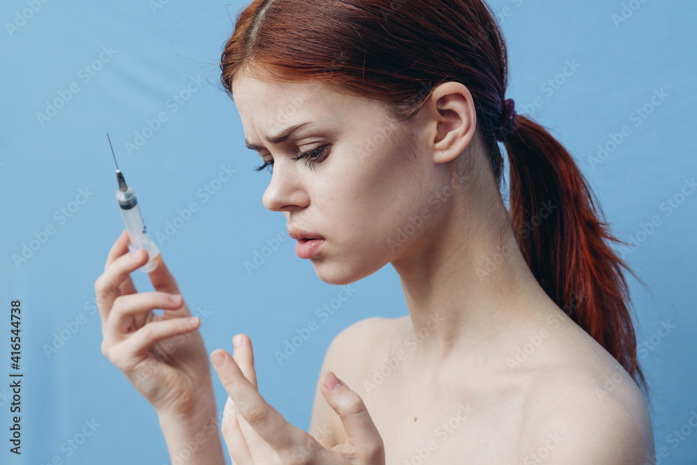 woman holding syringe near face botox rejuvenation injection blue background woman holding syringe near face botox rejuvenation injection blue background