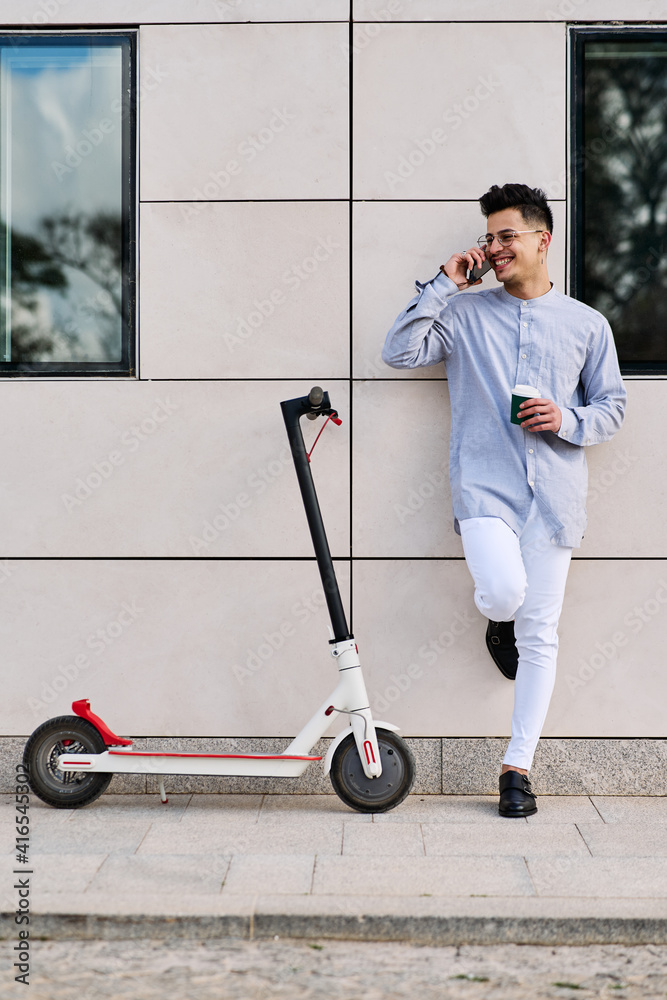 young man on a scooter talking on the phone