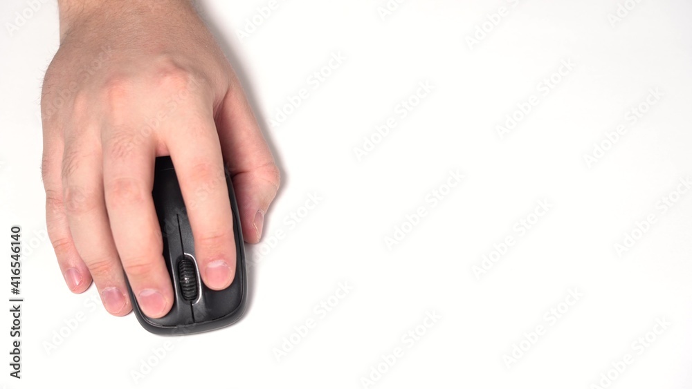 Hand with Wireless Computer Mouse Moves and Clicks. Copy Space. Top view shot. Close-up. White background. Hand with Wireless Computer Mouse Moves and Clicks. Copy Space. Top view shot. Close-up. White background.
