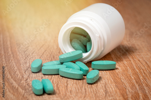 Pills spilled on a wooden office desk