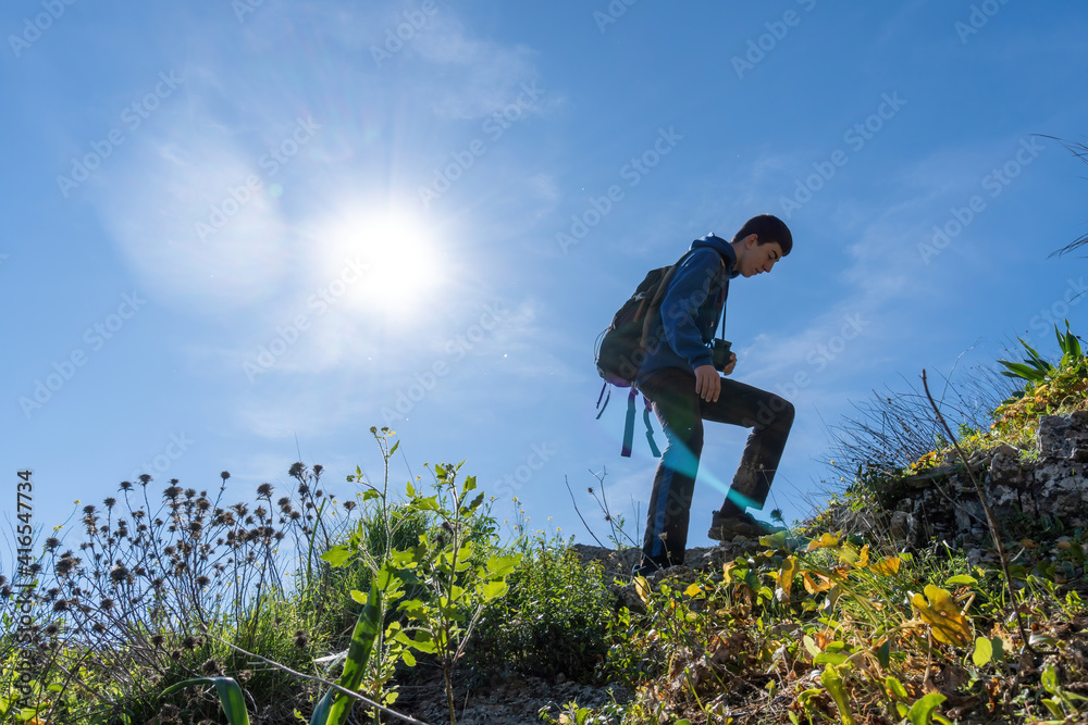 Active young boy wearing sportswear walking in the mountain during sunny day. Active young boy wearing sportswear walking in the mountain during sunny day.