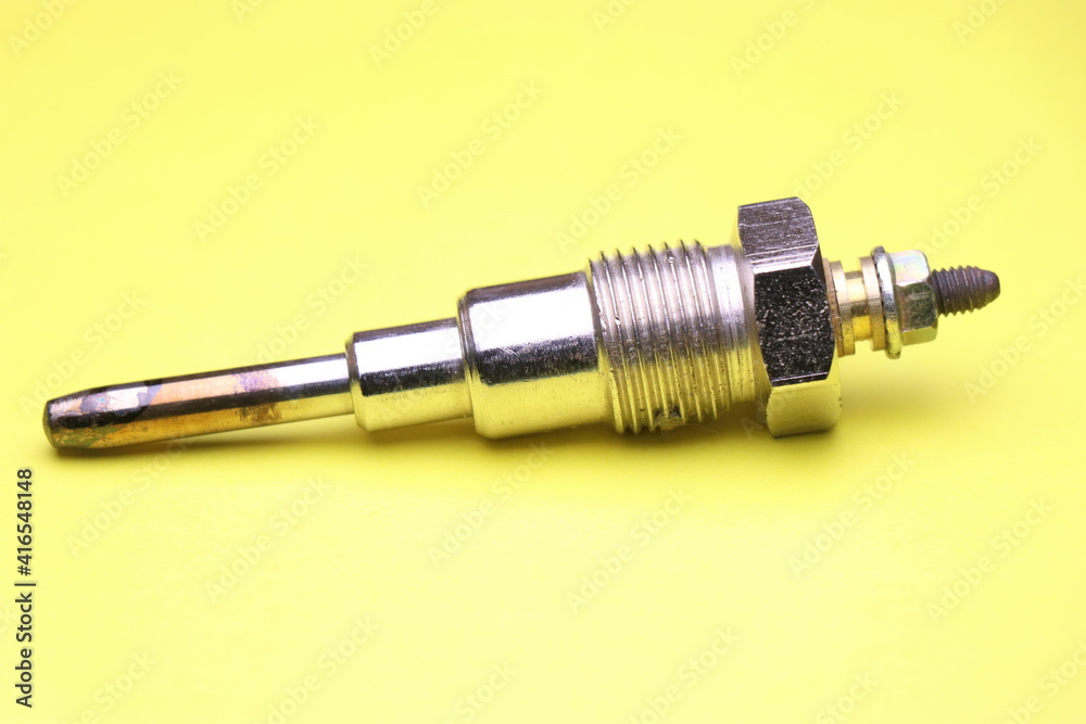 Glow plugs for diesel engine on yellow background. Glow plug which is spare part for automobiles. Single type glow plug Glow plugs for diesel engine on yellow background. Glow plug which is spare part for automobiles. Single type glow plug