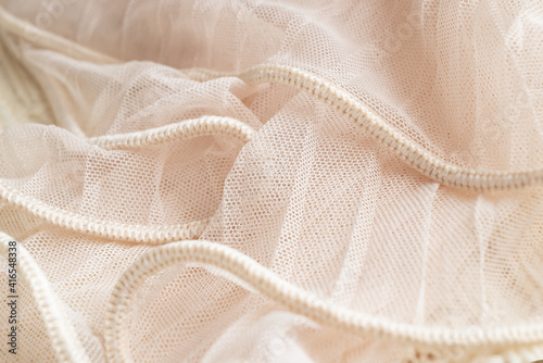 Ivory colored tulle fabric texture. Textile background