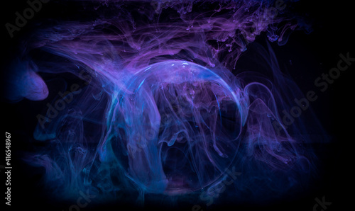 Swirling clouds of colored light around a sphere on a dark background