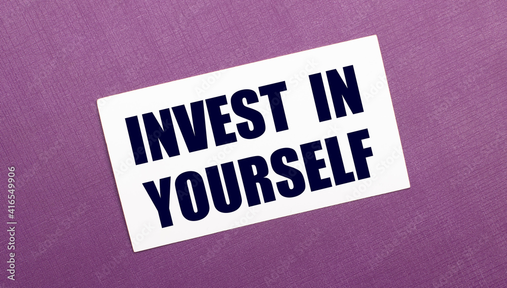 On a lilac background, a white card with the words INVEST IN YOURSELF On a lilac background, a white card with the words INVEST IN YOURSELF