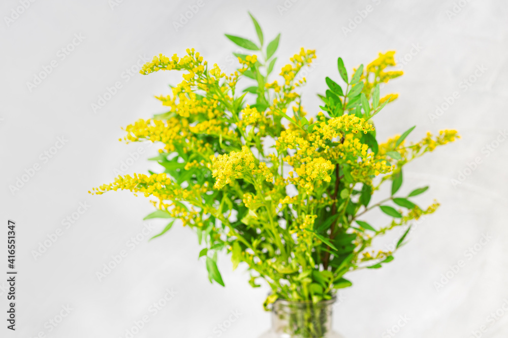 Bouquet of fresh yellow flowers ion light gray background. Selective focus.