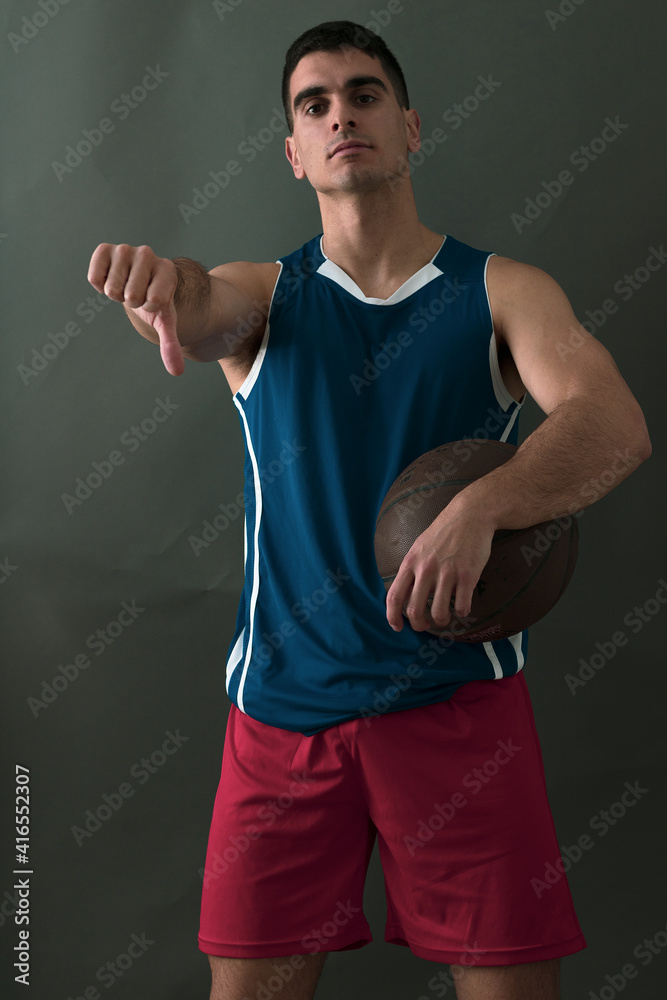 young man posing with a basketball in a photo studio
young man posing with a basketball in a photo studio