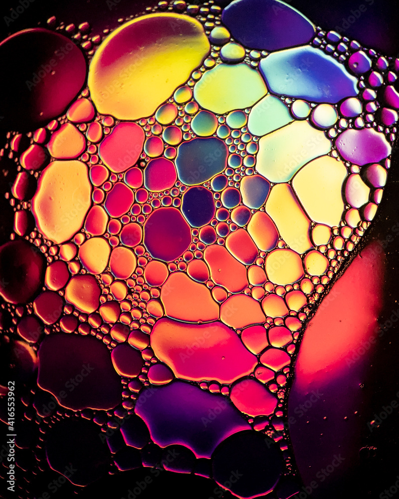 Oil drop bubbles on a water surface abstract with a bright orange and red background