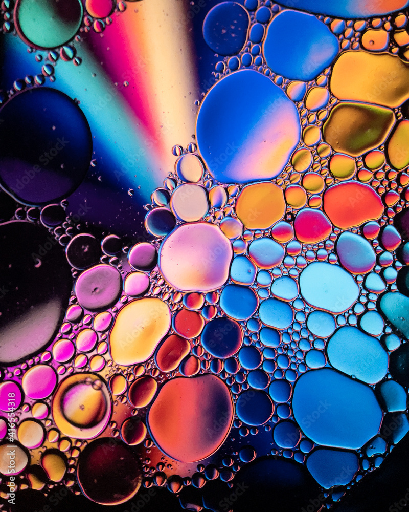 Oil drop bubbles on a water surface abstract with a blue, orange and red starburst background