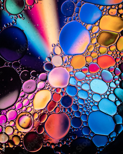 Obraz na płótnie Oil drop bubbles on a water surface abstract with a blue, orange and red starburst background w salonie