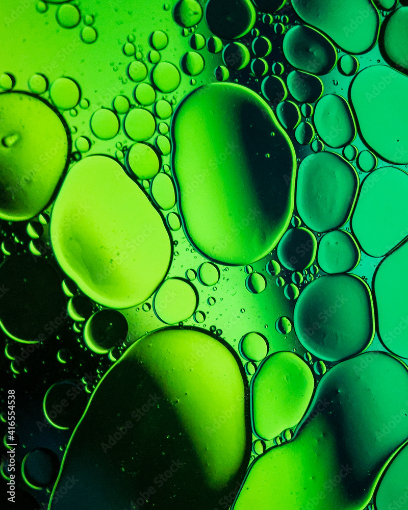 Oil drop bubbles on a water surface abstract with a green stripe background