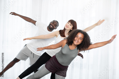 Family training yoga on the mat at home