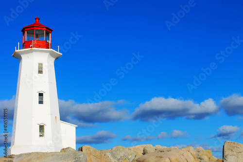 Light house at Peggy s Cove  Nova Scotia. Sunny  autumn day  lots of blue sky with light cloud. Lots of copy space.