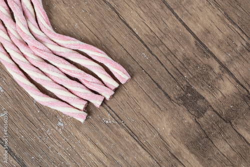 Pink white spiral shape jellybeans on a wooden board