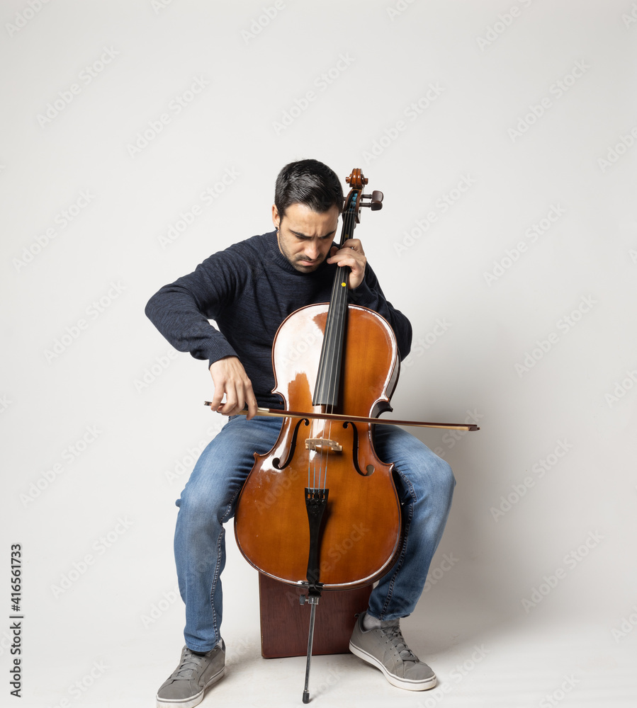 young man playing cello on the white background young man playing cello on the white background