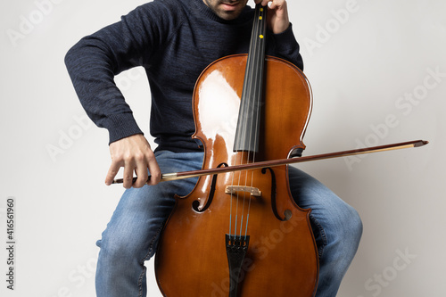 young man playing cello on the white background