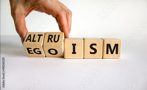 Altruism or egoism symbol. Businessman turns wooden cubes and changes the word 'egoism' to 'altruism'. Beautiful white background, copy space. Business, psychological and altruism or egoism concept.