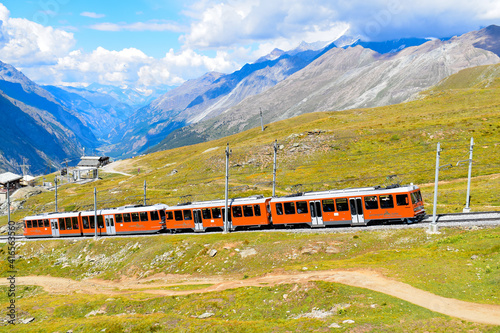 Beautiful Swiss Alps scene and red train going up to Gornergrat station during summer, Switzerland, Europe. 