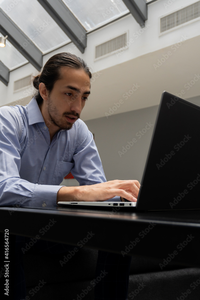 vertical photo of a man using computer in office. freelancing vertical photo of a man using computer in office. freelancing