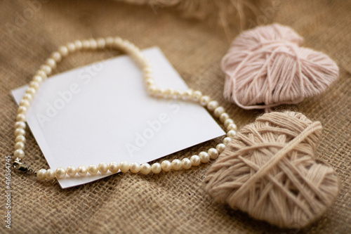 heart made of knitting needles. Hearts on a textile fabric. Place for text. Heart made of pearls around paper. Knitted heart on the table. Love