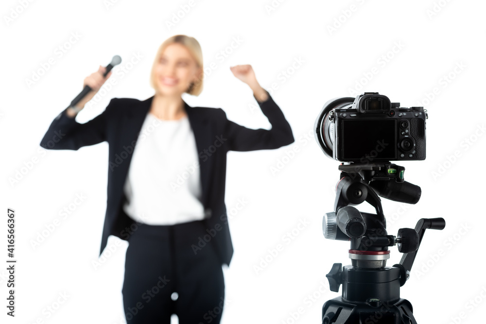 selective focus of digital camera near news anchor showing success gesture on blurred background isolated on white selective focus of digital camera near news anchor showing success gesture on blurred background isolated on white