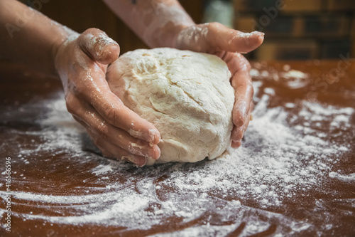 Kneading bread on a wooden table.