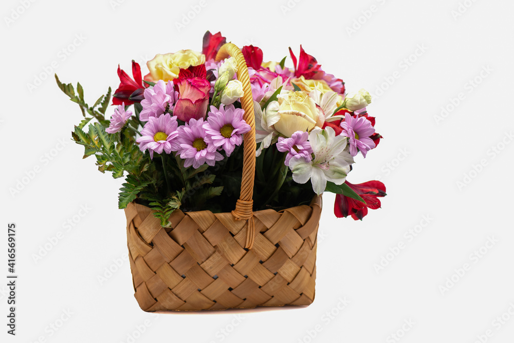 Obraz premium Bouquet of flowers in a basket on a white background
