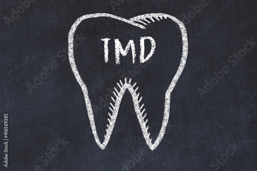 Chalk drawing of a tooth with medical term TMD. Concept of learning stomatology photo