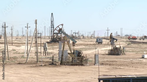 A rocking rod pump pumps oil in the desert.