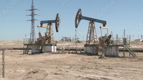 A rocking rod pump pumps oil in the desert.