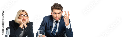 Fotografie discouraged broadcaster gesturing near upset colleague isolated on white, banner