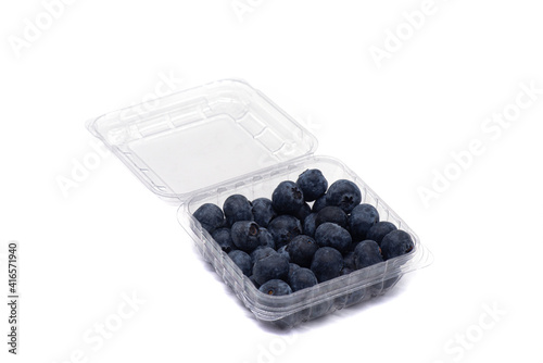 Blueberries in a plastic container on a white background