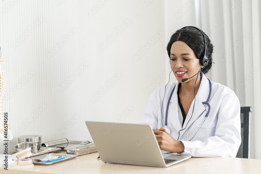 african woman doctor in headset taking calling on her headset microphone online for a ache patient african woman doctor in headset taking calling on her headset microphone online for a ache patient